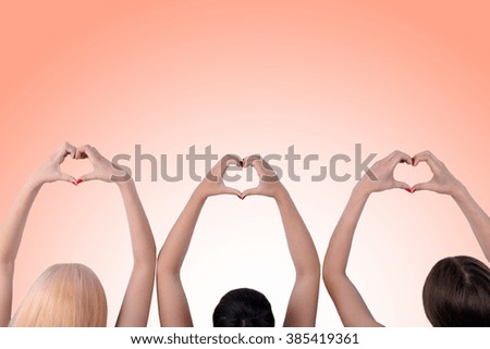 Young people makes hearts using fingers on light background