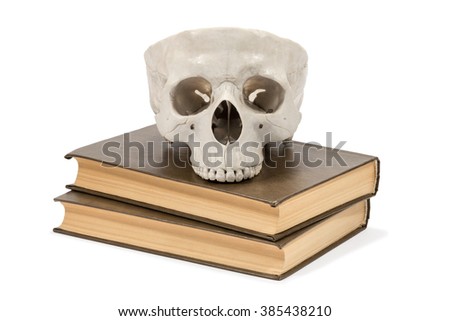 Part of a human skull lying on the two brown books isolated on white background