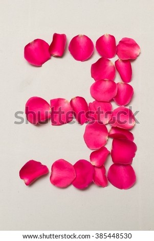 digit arranged by Red rose petals, white background isolated, number 3