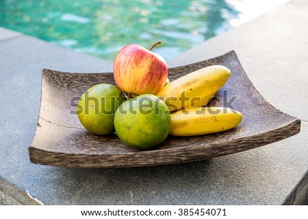 Apple Oranges and bananas in wood plate