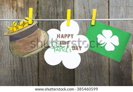 happy St Patrick's Day card, March 17, with Leprechaun hat and pot of gold, on pegs ( clothespin ) wooden background.