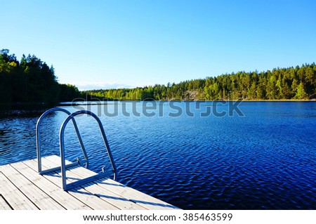 Big swimming pool in nature, "Cloud" lake in Finland. Clear and blue sky Royalty-Free Stock Photo #385463599