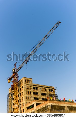 An under construction building with working crane at sunset in Hanoi, the capital of Vietnam. Its a dynamic and energetic city on the move. Urban development concept. Industrial Background.