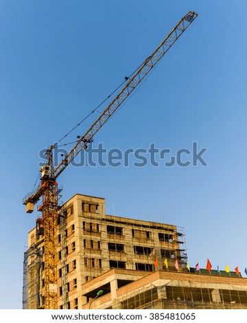 An under construction building with working crane at sunset in Hanoi, the capital of Vietnam. Its a dynamic and energetic city on the move. Urban development concept. Industrial Background.