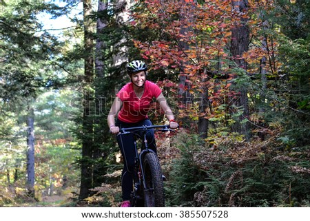 Young female girl mountain bike cycling on a trail in the woods