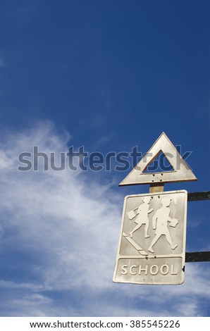 an old warning sign indicates a school near