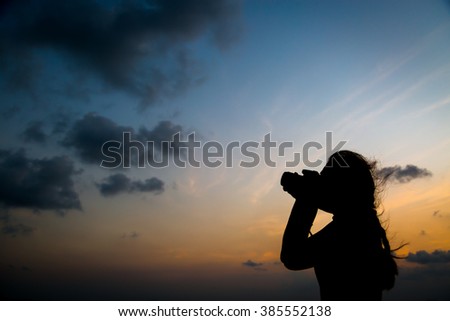 Silhouette  photographer taking a picture on sunset background