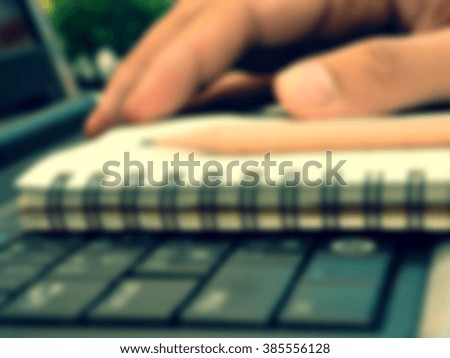 Blur image of man hands with pencil on notebook