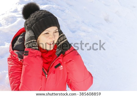 happy middle-aged woman looking to the side. snow background