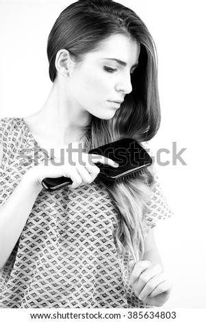 fashion woman brushing her long hair with care. Black and white