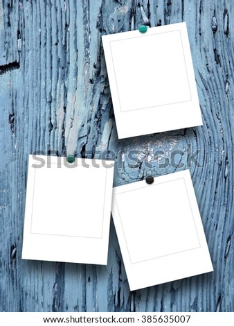 Close-up of three square photo frames with pins on blue tree bark background