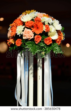 Flowers bouquet with white ribbon on blur background.
