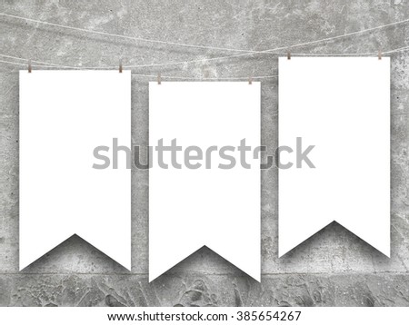 Close-up of three hanged medieval standard flags on grey weathered wall background