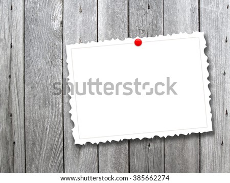 Close-up of one vintage postcard with red pin on monochrome wooden boards background