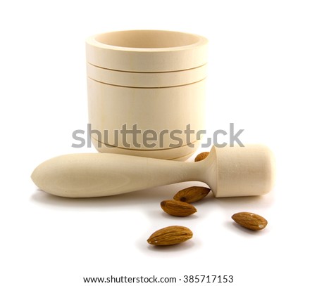 Wooden mortar with pestle and almonds isolated on white background