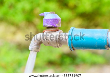 Purple faucet with blue pipe and water drop:Close up,select focus with shallow depth of field