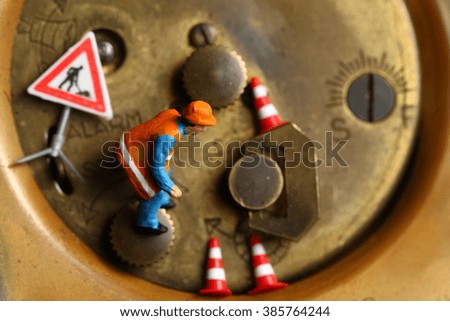 The back side of old and dirty brass table clock and miniature maintenance figure plastic model represent the clock service and time concept related idea.