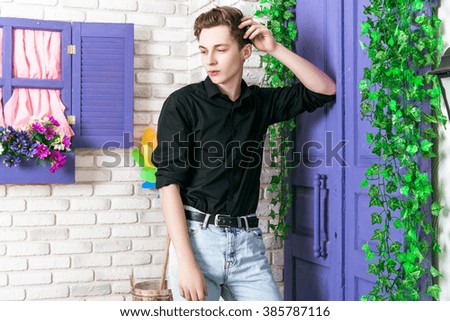 handsome man in a bright interior with flowers studio. Spring scenery.