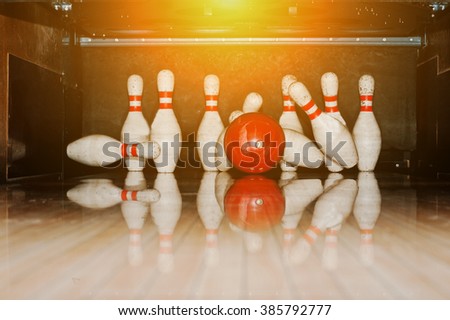 Ten white pins in a bowling alley with ball hit