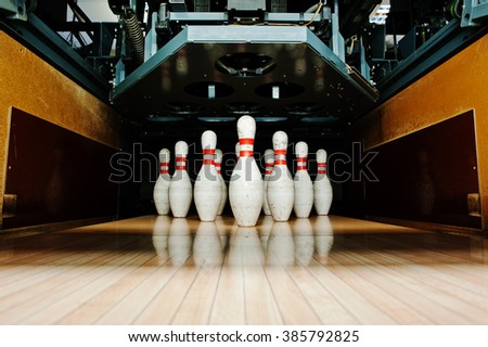 Ten white pins in a bowling alley lane
