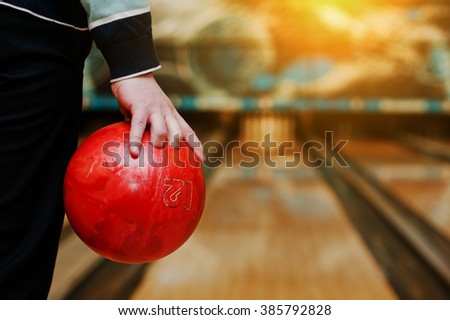 Bowling ball at hand of man background bowling alley