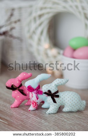 
Handmade textile easter bunnies on a white wooden background in a light interior