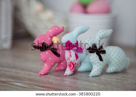Handmade textile easter bunnies on a white wooden background in a light interior