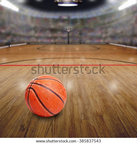 Realistic rendering of basketball arena full of fans in the stands with ball on court and copy space. Deliberate focus on seasoned basketball and shallow depth of field on background.