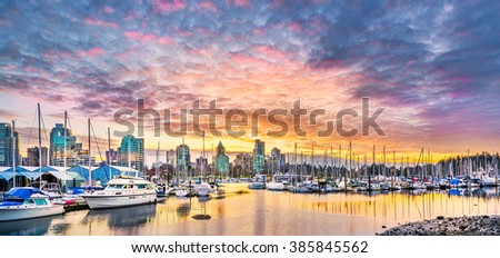 Stunning view of Coal Harbor in British Columbia featuring beautiful downtown buildings, boats,  and reflections on the water