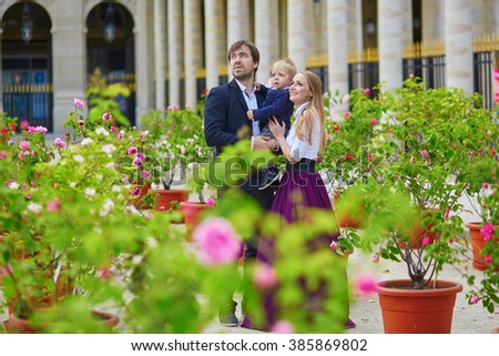 Happy family of three in the beautiful garden of Palais Royal in Paris on a summer day