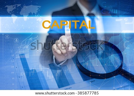 Businessman hand touching CAPITAL button on virtual screen