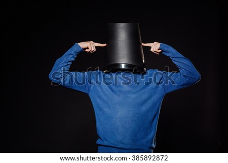 young man holding a black bucket. ecologycal concept, emotions, facial expressions, feelings, body language, signs. image on a black studio background.