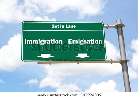 Green overhead road sign with the instruction to get in lane with an Immigration or Emigration concept against a partly cloudy sky background.