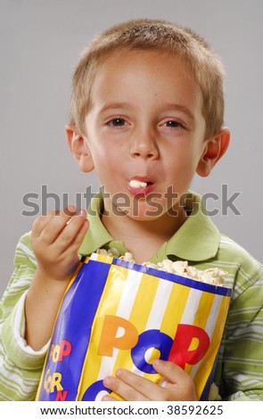 One little boy holding a popcorn bag.boy holding a popcorn bag.  Boy eating popcorn.