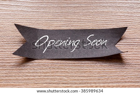 Opening Soon words written on Black papper with wooden background