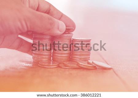 Human hand picking coins placed.