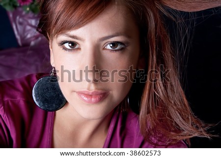 Closeup portrait of a pretty young woman with ear-ring, studio shot