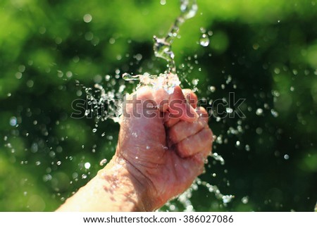 Clinching fist in splashing water.