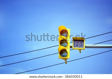  Traffic light at intersection with clear blue sky.