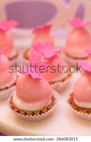 Pastel colored cupcakes and meringue. Berries tarts, peach and lemon tarts display. Candy Bar.