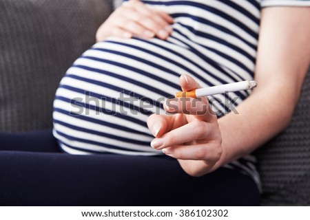 Close Up Of Pregnant Woman Smoking Cigarette Royalty-Free Stock Photo #386102302