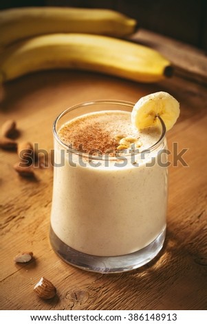 Banana cinnamon smoothie with peanut butter and oats in glass / Healthy breakfast concept