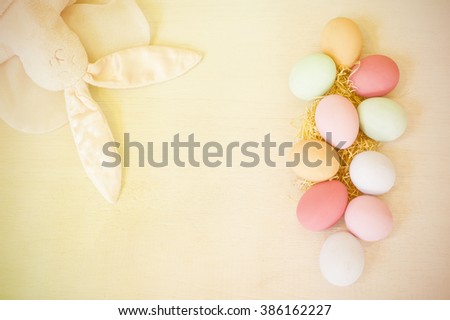 Easter eggs painted in pastel colors and rabbit doll on wood white background,pastel tone. 