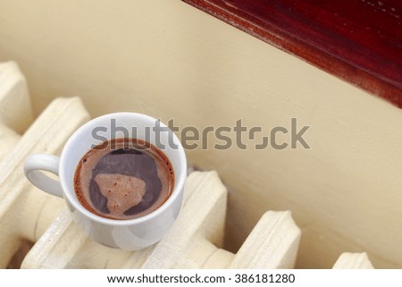 Cup of black coffee on old radiator