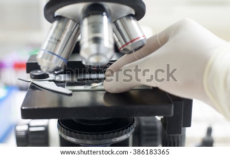 Hand scientist working in laboratory equipment Microscope. Royalty-Free Stock Photo #386183365