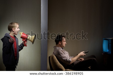 Man watching TV while his son calling him through a megaphone. Lack of father's attention concept
 Royalty-Free Stock Photo #386198905