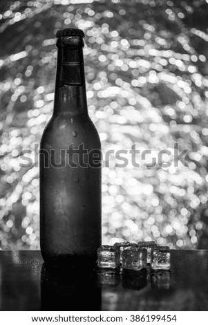 Cold beer with ice cubes on the background bokeh.