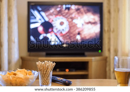 Television, TV watching (basketball game) with snacks and alcohol lying on table - stock photo