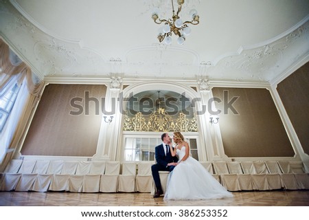 Beautiful blonde bride with groom at grand palace 