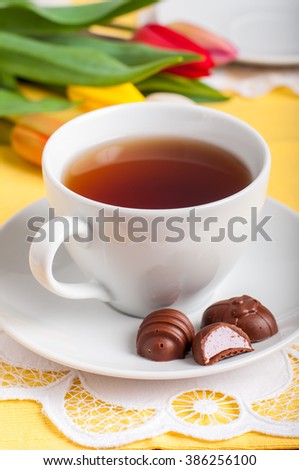 A Cup of Tea and Easter Egg Shaped Chocolate Candies with Marshmallow Filling, copy space for your text
